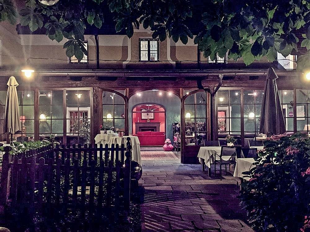 stimmungsvoller Garten mit Blick auf ein rotes Sofa, Hauben-Restaurant im Romantik Hotel GMACHL, Rezept Salzburger Nockerl