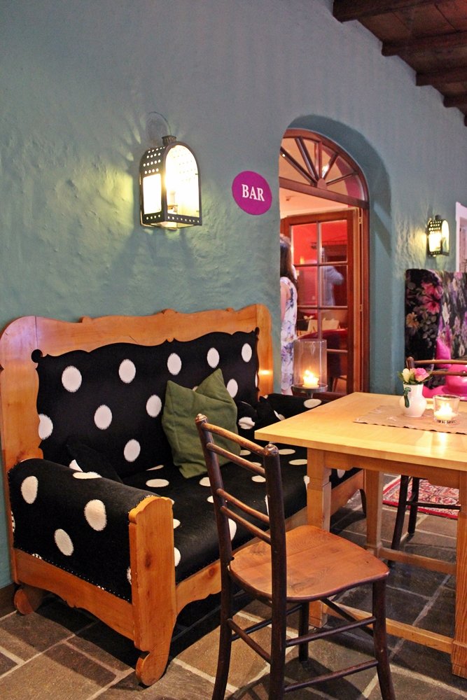 schwarz-weiß gepunktetes Sofa vor grüner Wand, Hauben-Restaurant im Romantik Hotel GMACHL